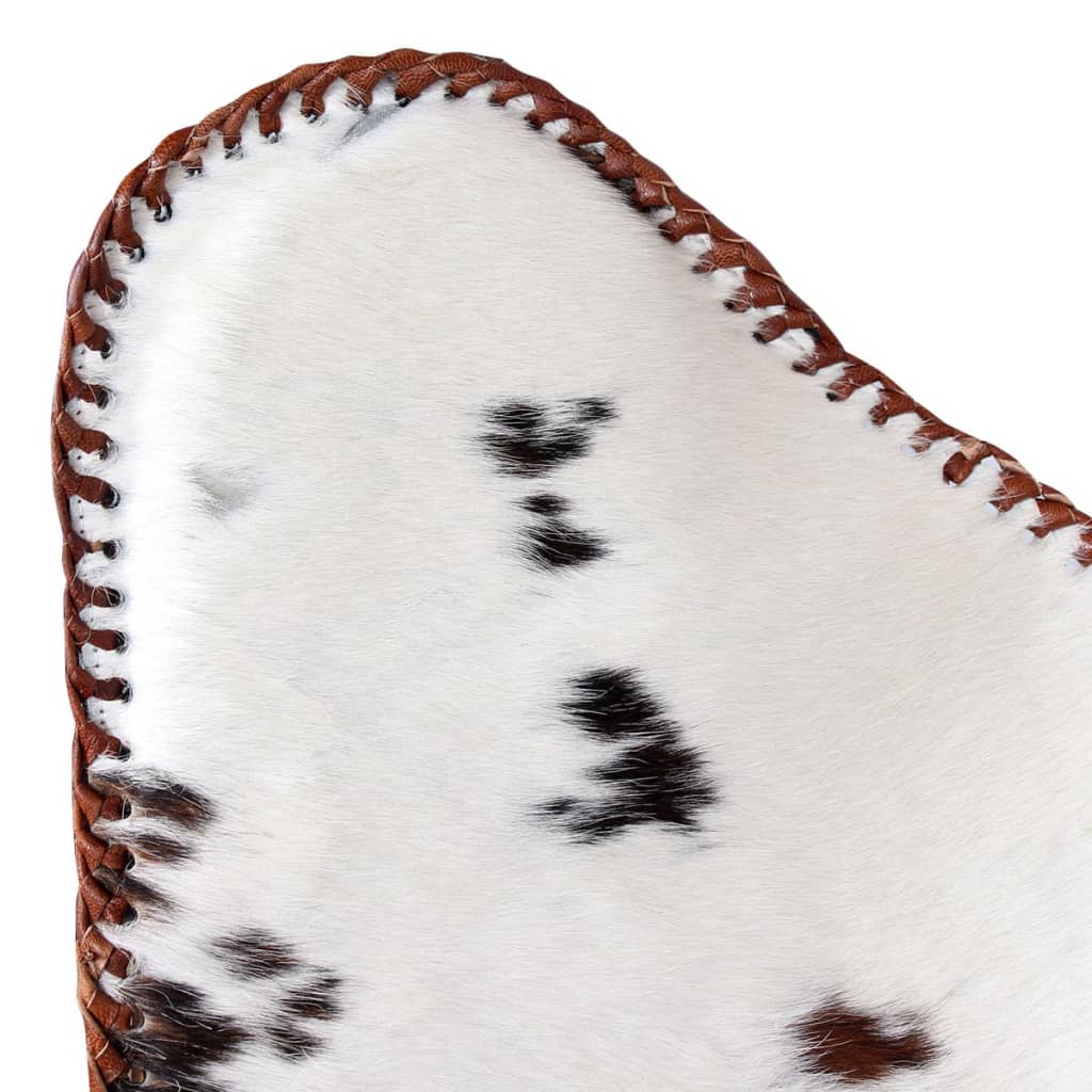 Close-up of the brown and white cowhide leather on a vintage butterfly chair, showcasing its unique texture and stitching.