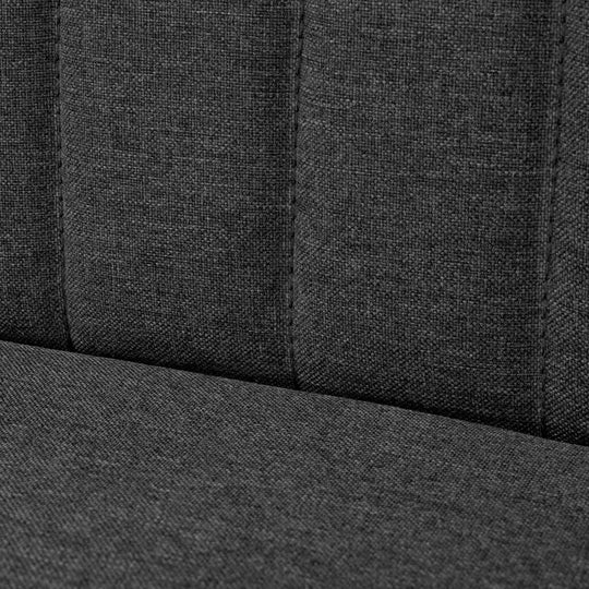 Close-up of dark grey fabric upholstery on a modern sofa, highlighting the texture and padded design for comfort.