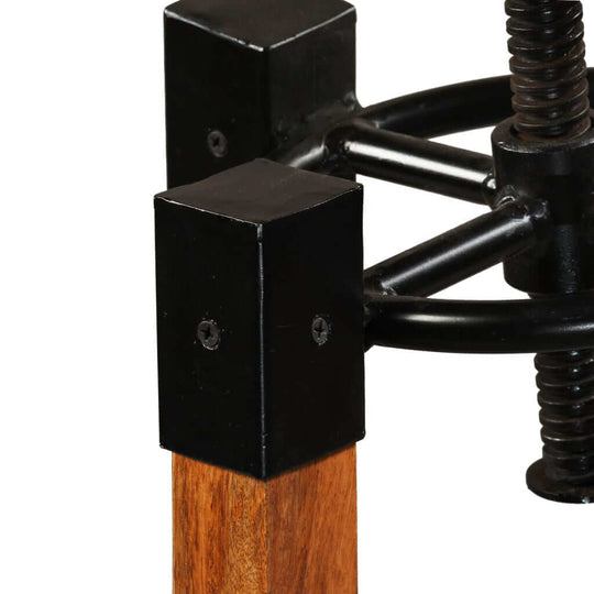 Close-up of bar stool base showcasing solid mango wood and black metal components, highlighting industrial design and stability.