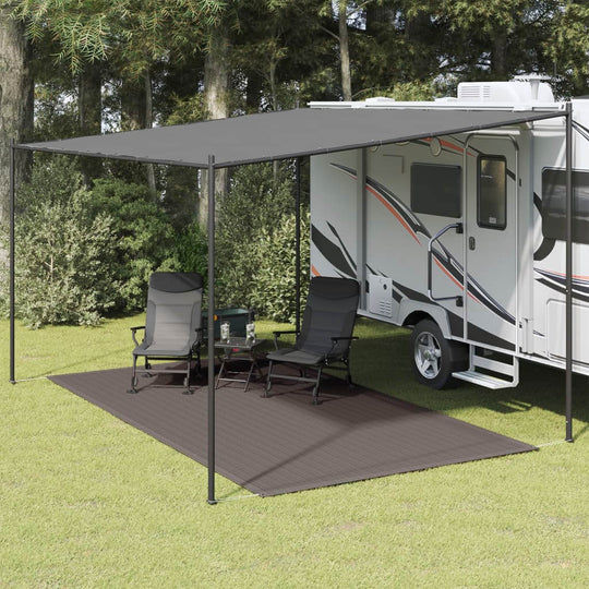 Tent carpet placed under an awning beside an RV, creating a comfortable outdoor lounge area with chairs.
