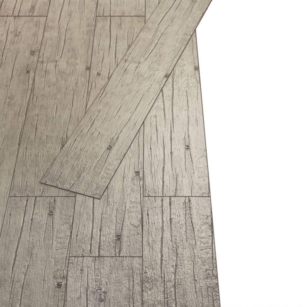 Self-adhesive PVC flooring planks showing natural wood texture in oak washed design, ideal for durable home flooring solutions.