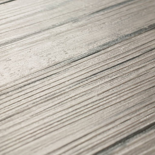 Close-up of self-adhesive PVC flooring planks in oak washed finish, showcasing natural wood texture and patterns.