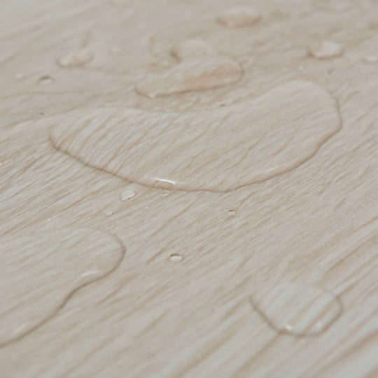 Water droplets on oak classic white self-adhesive PVC flooring, showcasing its waterproof surface.