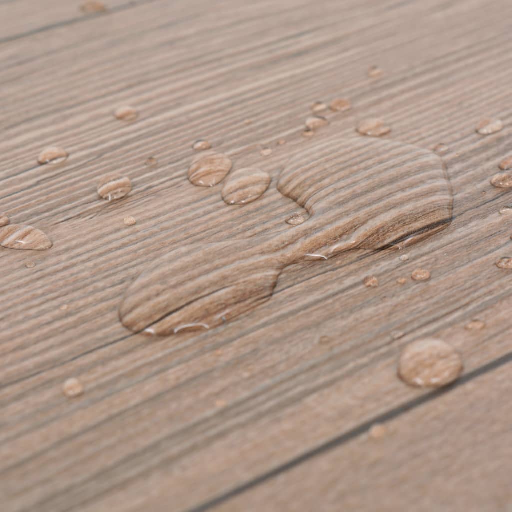 Water droplets on oak brown self-adhesive PVC flooring planks showcasing durability and water resistance.