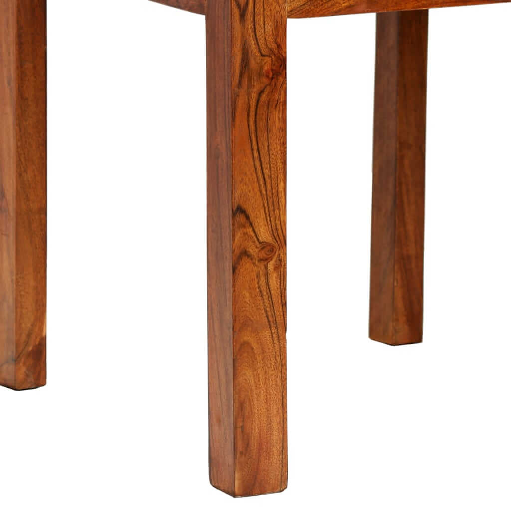 Close-up of solid acacia wood dining chair leg showcasing honey finish and unique wood grain pattern.