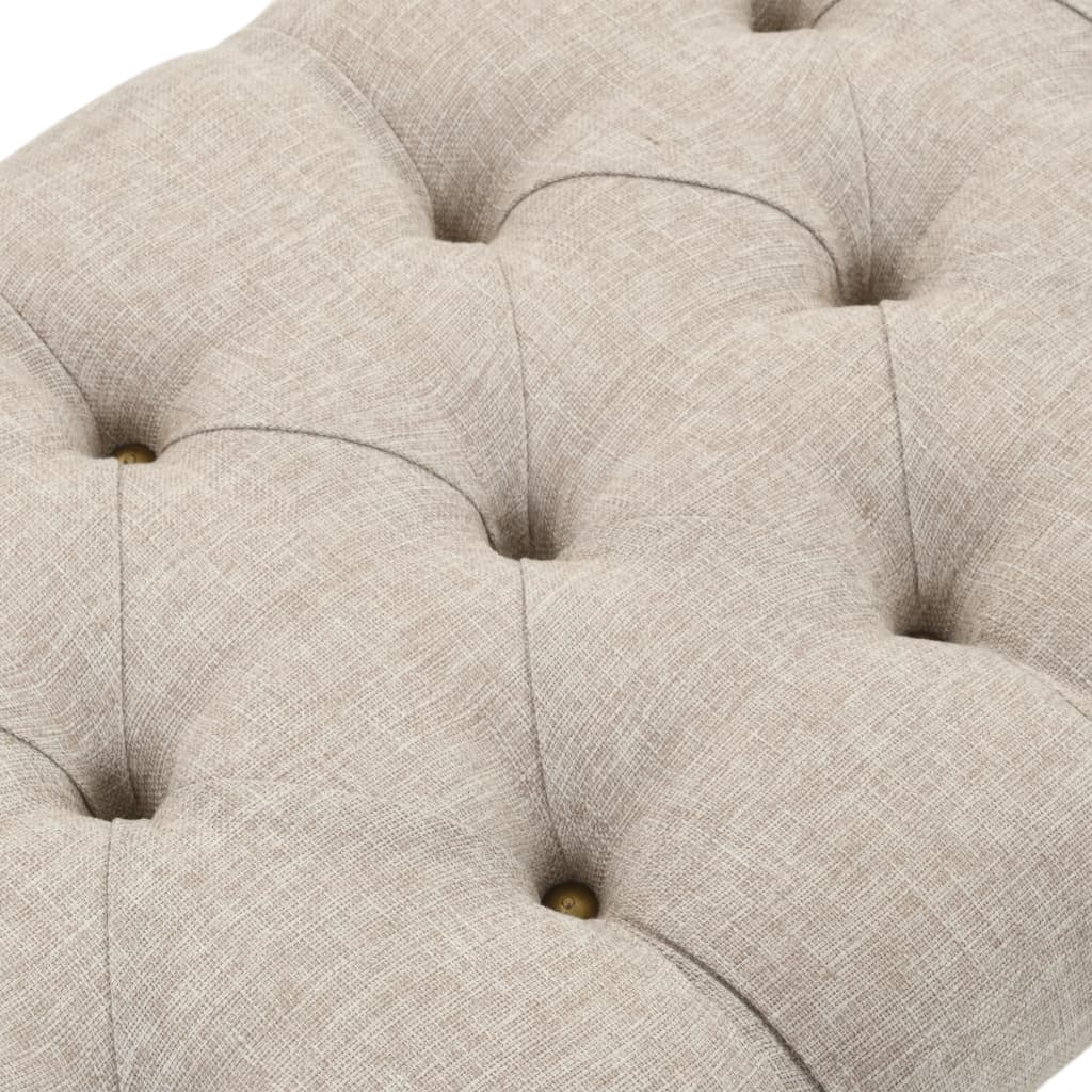 Close-up of a beige upholstered bench top with tufted fabric and decorative buttons for stylish home storage solutions.