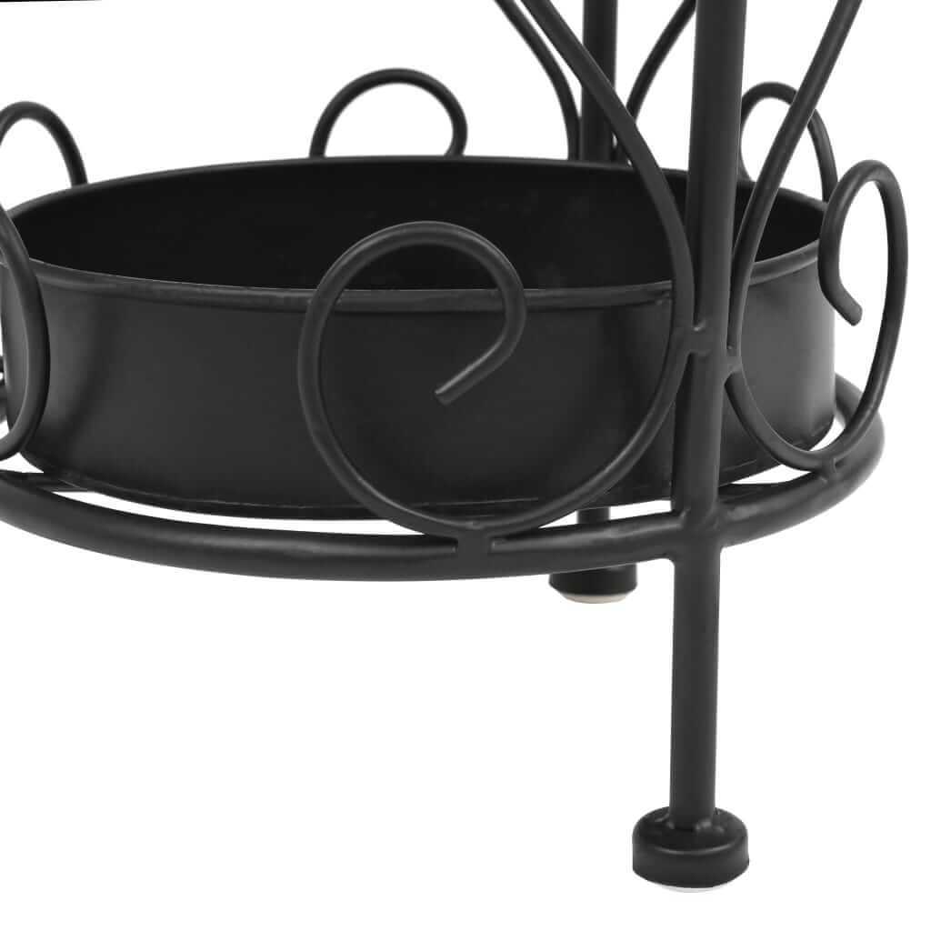 Vintage black metal umbrella stand with scrollwork and drip tray, perfect for elegant home decor and outdoor furniture.