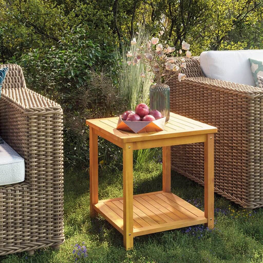 Solid acacia wood side table outdoors, featuring fruits and flowers, complementing rattan chairs in a garden setting.