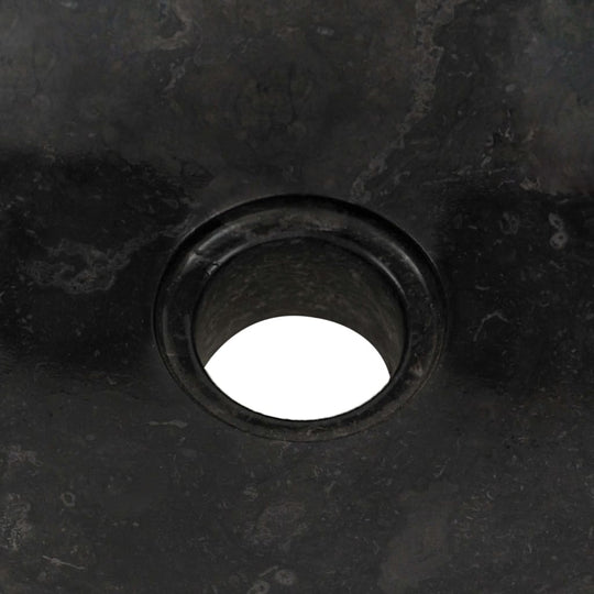 Close-up of a black marble sink showcasing the elegant drain hole, perfect for rustic bathroom decor and functional use.