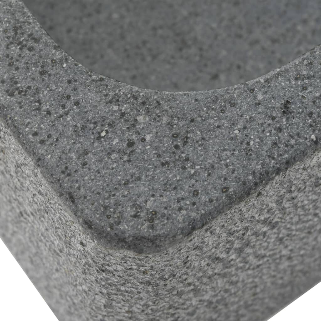 Close-up of a natural river stone sink showcasing its rustic texture and sturdy construction in gray.