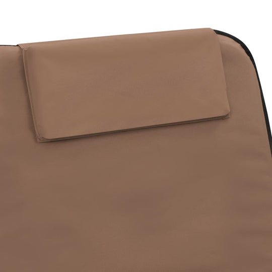 Close-up of a folding beach mat featuring a built-in headrest in brown fabric, ideal for relaxation at the beach.