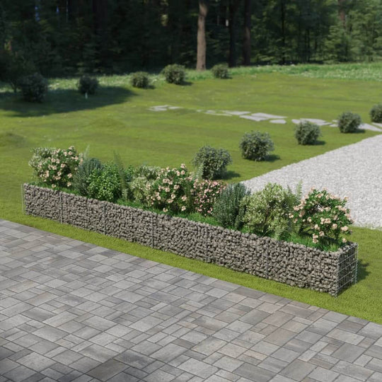 Gabion raised bed made of galvanised steel filled with rocks, showcasing plants and flowers in a garden setting.