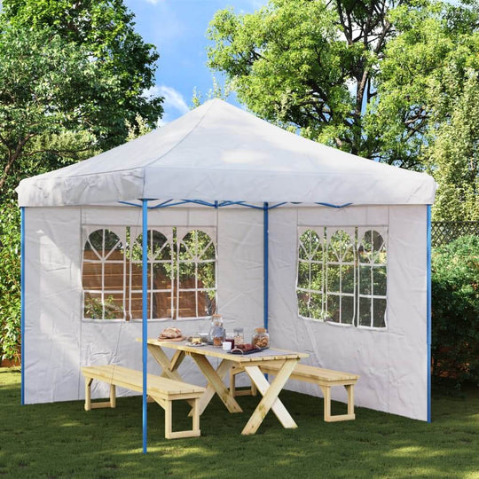 Outdoor party tent with sidewalls and windows, featuring a picnic table set in a garden area. Perfect for gatherings.