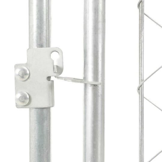 Close-up of a metal latch and post for an outdoor dog kennel, featuring durable chain link design.