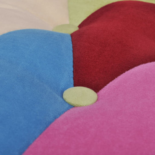 Close-up of vibrant patchwork fabric with buttons on a French chair, showcasing colorful design elements for interior decor.