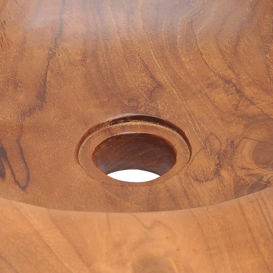 Close-up of a solid teak basin showcasing the handmade craftsmanship and circular drain hole design.