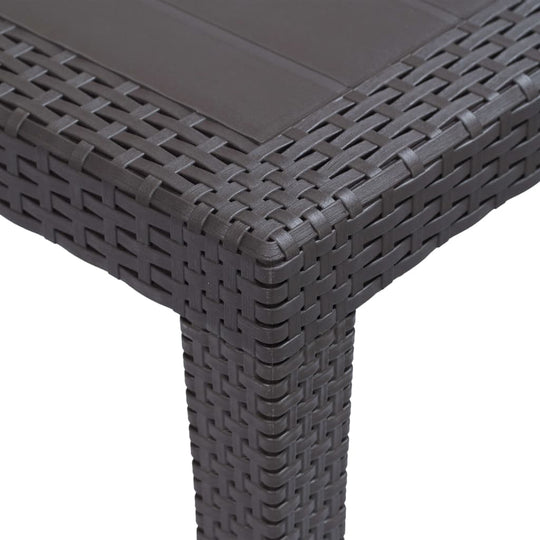 Close-up of the rattan look finish on a durable brown plastic garden table corner, showcasing its woven texture and design.