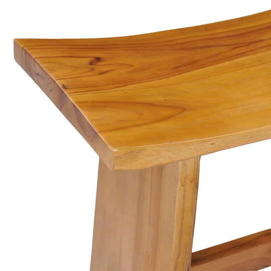 Close-up view of a solid teak wood stool showcasing its smooth, curved surface and sturdy construction.