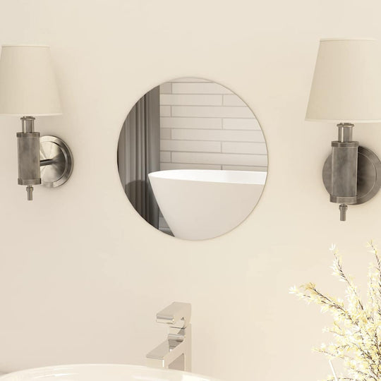 Round frameless mirror reflecting modern bathroom design with stylish wall sconces and soft lighting.