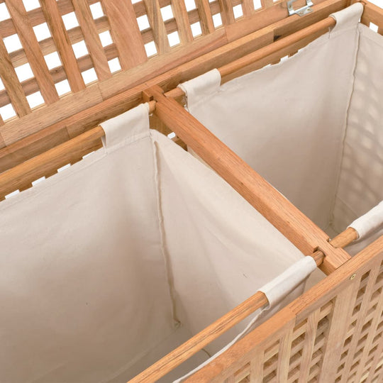 Wooden laundry bin with lattice design and two separate fabric compartments for organized storage. Ideal for bathroom or bedroom furniture.
