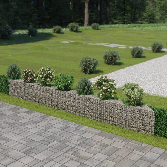 Gabion wall made of galvanized steel with plants and flowers in a landscaped garden setting.