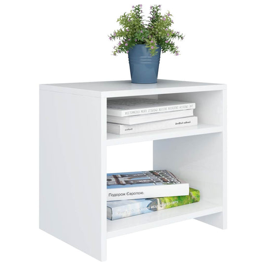 White bedside cabinet with open storage compartments, books, and a potted plant on top.