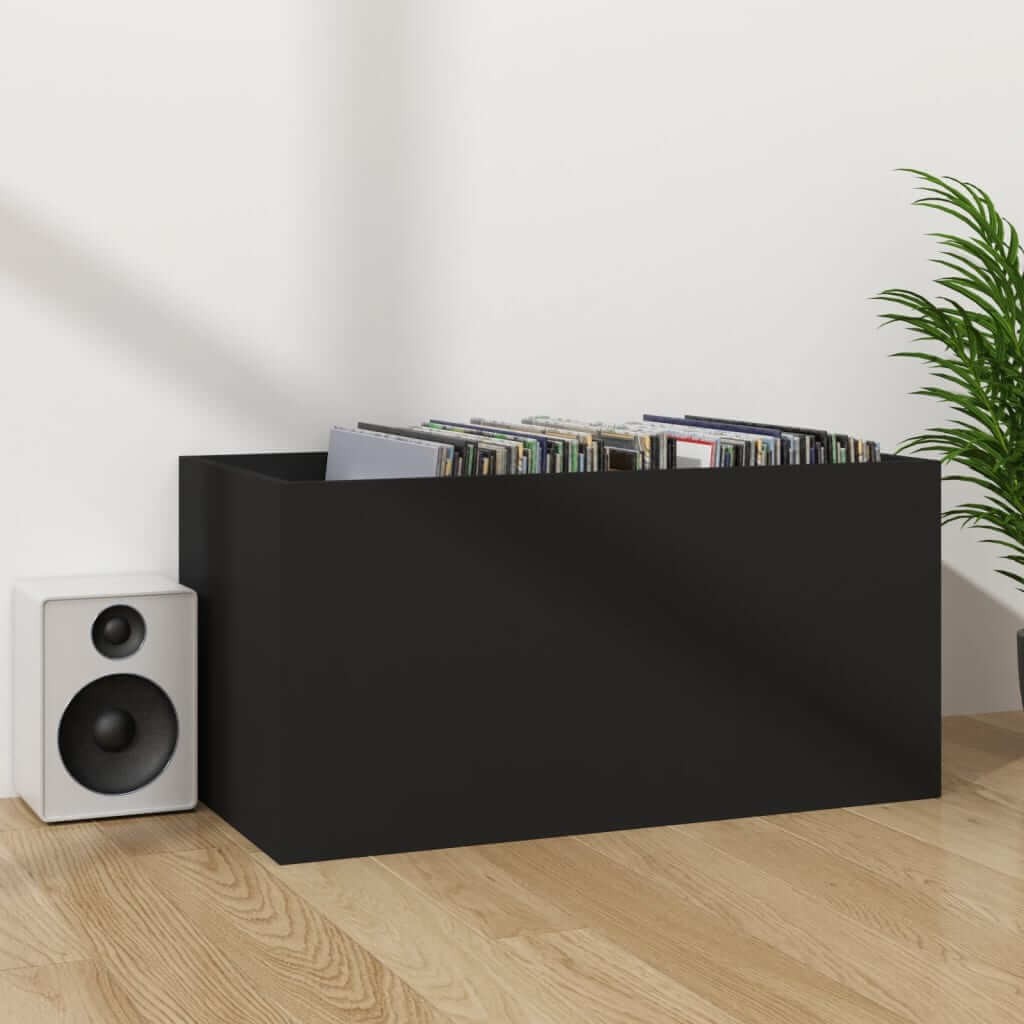 Black vinyl storage box holding records beside a speaker on wooden floor, perfect for organizing music collections.