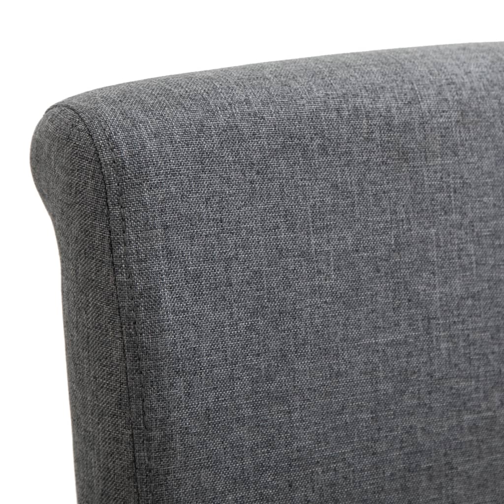 Close-up of the soft grey fabric upholstery on a dining chair, showcasing its quality and comfortable design.