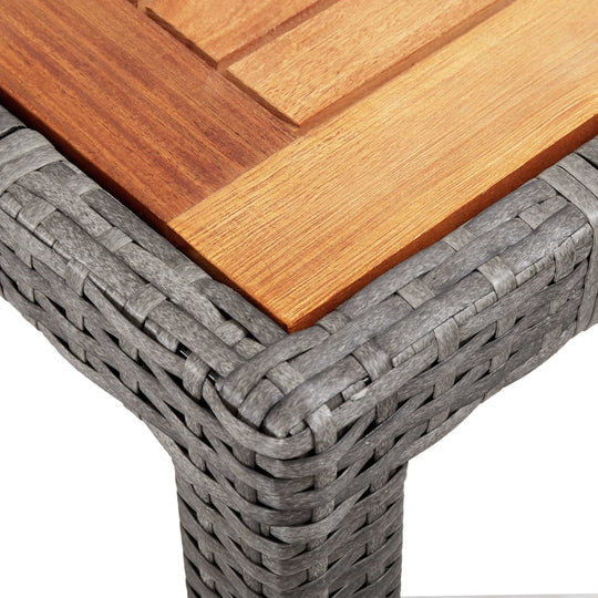 Close-up of grey poly rattan weave and wooden tabletop of a stylish outdoor dining set, perfect for garden furniture.