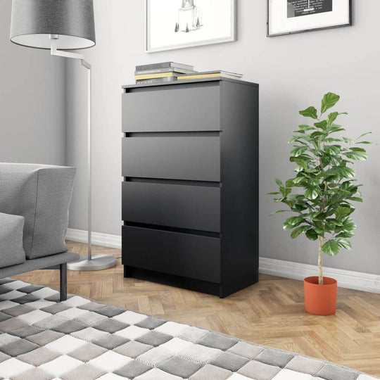 Minimalist black sideboard with four drawers in a modern living room setting, displaying books and greenery.