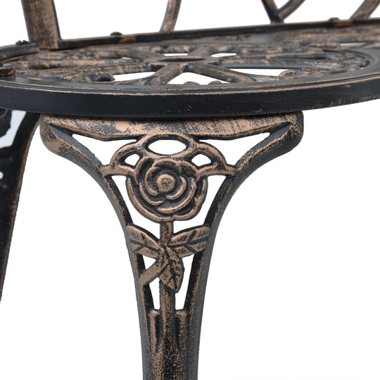 Close-up of ornate bronze cast aluminium bench leg with floral scrollwork design for outdoor furniture.