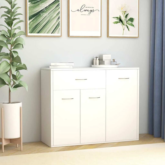 Minimalist white sideboard with storage drawers and doors, set against a modern wall with decorative plants and artwork.