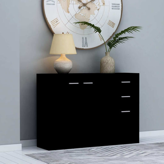 Black sideboard with three drawers, two doors, and decorative items in a modern living room setting.