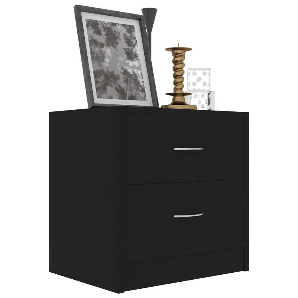 Black bedside cabinet with two drawers, styled with a picture frame, candle holder, and decorative glass on top.