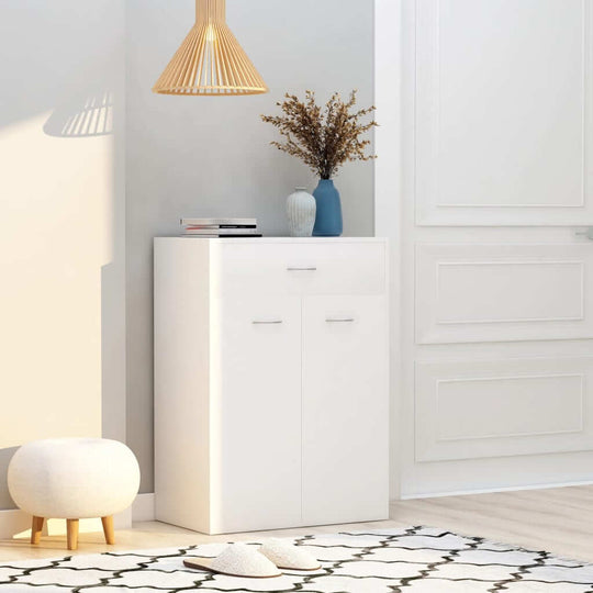 White shoe cabinet with two doors and a drawer, stylishly arranged in a bright living space, ideal for organized storage.