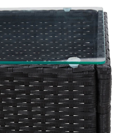 Close-up of a black poly rattan coffee table with a glass top, showcasing its unique woven design and weather-resistant features.