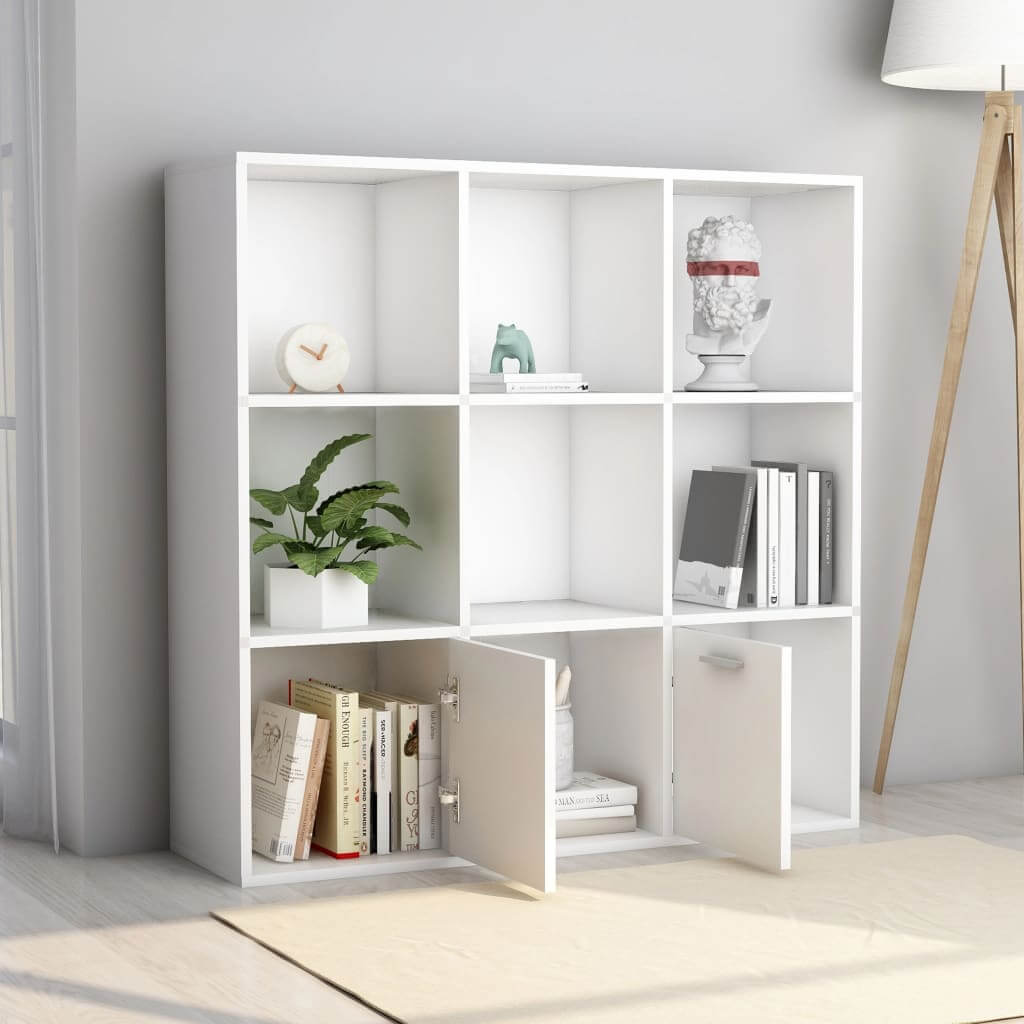 White book cabinet with open cubes and doors, showcasing books and decorative items in a modern living space.