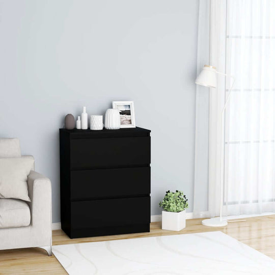 Minimalist black sideboard with three drawers in a modern living room setting, featuring decorative elements on top.