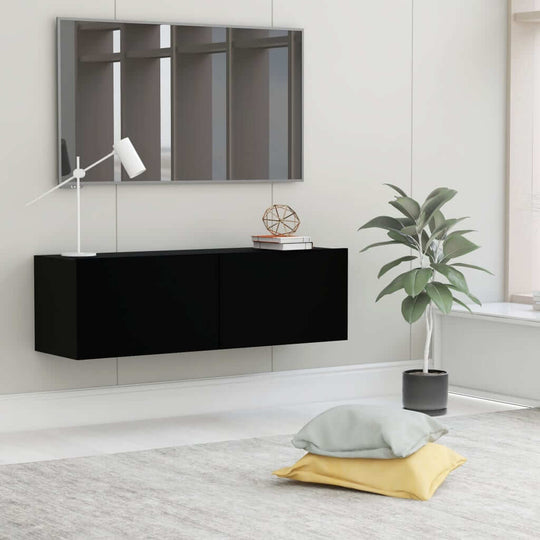 Wall-mounted black TV cabinet in modern living room with decor, emphasizing stylish and functional home furniture design.