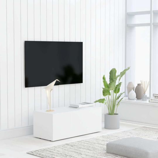 Modern white TV cabinet with plants and decor in a bright, minimalist living room setting.