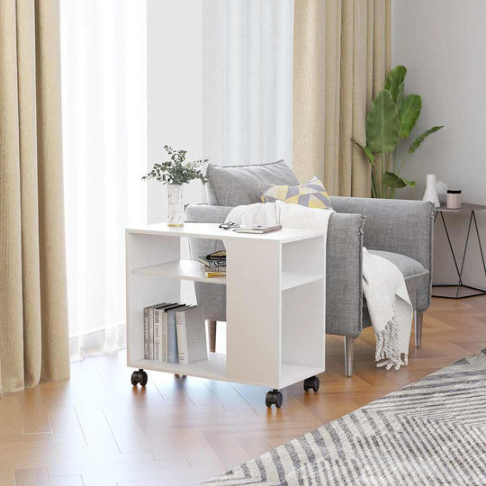 Stylish white side table on wheels next to a gray couch, featuring books and decor, enhancing modern interior design.