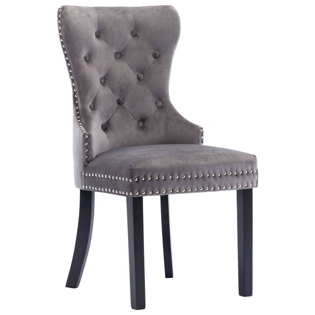 Elegant grey velvet dining chair with button tufting and metal rivets, perfect for stylish dining and lounge areas.