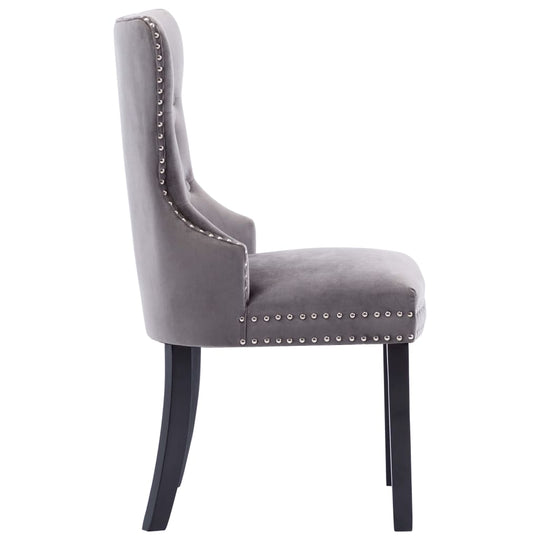 Side view of grey velvet dining chair with decorative button backrest and metal rivets, supported by black rubberwood legs.