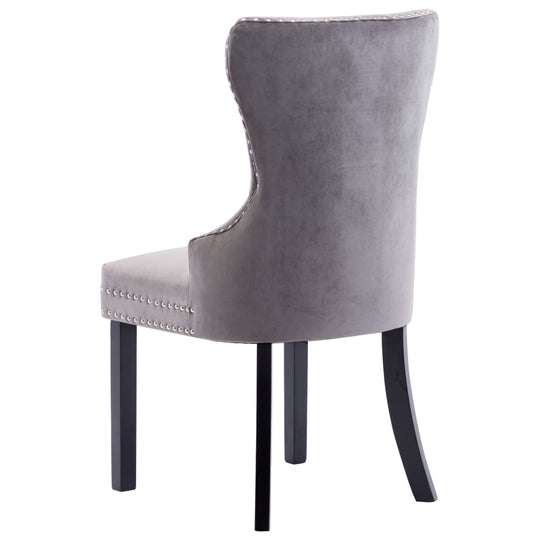 Grey velvet dining chair with decorative buttons and metal rivets, supported by solid rubberwood legs. Ideal for stylish dining.