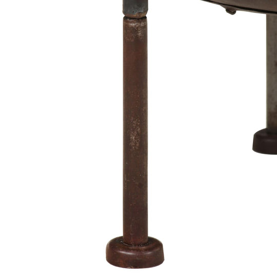 Close-up of Rustic Fire Pit – Durable Iron Outdoor Heater leg showcasing sturdy construction and rustic finish.