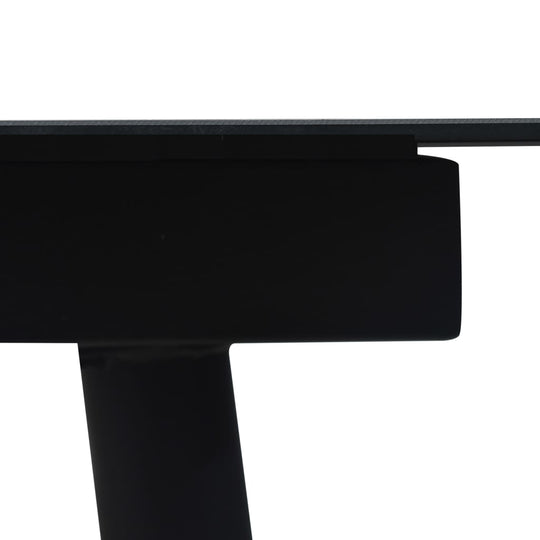 Close-up of the sturdy black steel frame of a garden dining table with a glass top, showcasing modern design and durability.