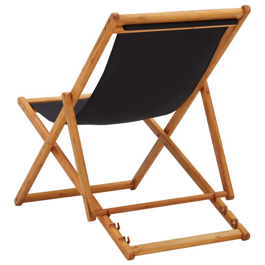 Eucalyptus wood folding beach chair with black fabric, adjustable reclining settings for outdoor comfort.