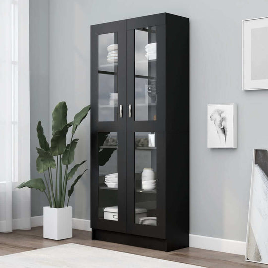 Vitrine cabinet in black engineered wood with glass doors, showcasing decorative items in a modern living room setting.