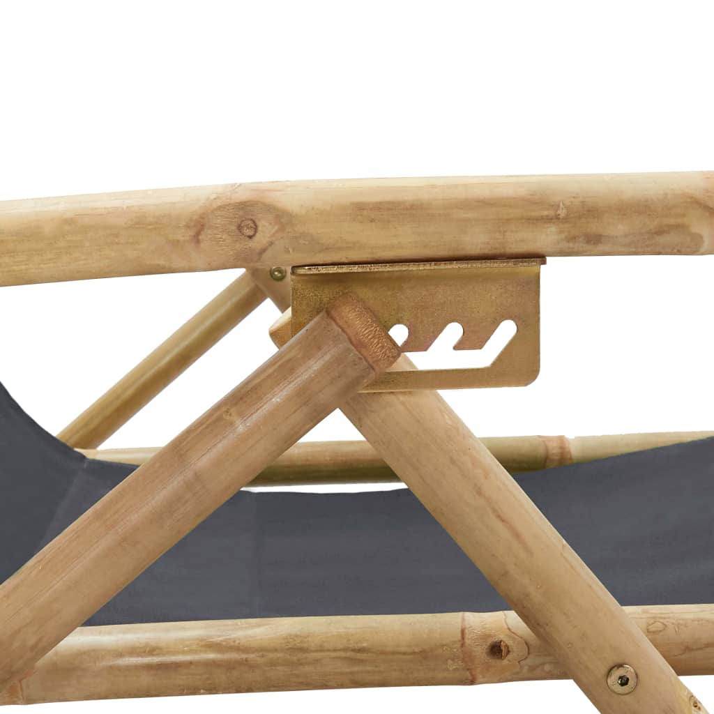 Close-up of the sturdy bamboo frame and adjustable mechanism of a dark grey folding relaxing chair. Ideal outdoor furniture for lounging.