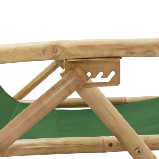 Close-up of the sturdy bamboo frame and adjustable metal bracket of a green fabric folding relaxing chair.